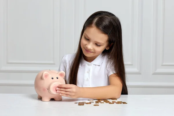 Menina criança com banco porquinho em casa — Fotografia de Stock