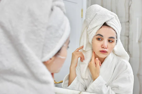 Mujer en albornoz blanco delante del espejo en el baño — Foto de Stock