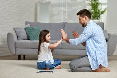 Küçük çocuk babasıyla evde oynuyor.