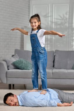 Mutlu küçük kız çocuğu babasına masaj yapıyor.