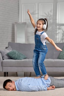 Mutlu küçük kız çocuğu babasına masaj yapıyor.