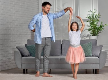 Baba evde küçük tatlı kızıyla dans ediyor.