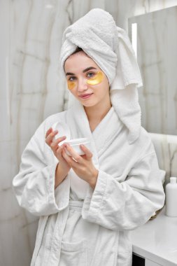 Banyoda beyaz bornozlu, göz bantlı güzel bir kadın.
