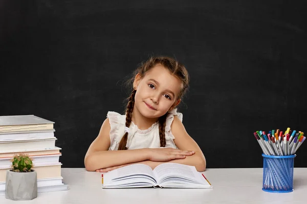 Klein kind meisje het lezen van een boek in de klas — Stockfoto