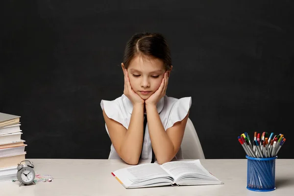 Fáradt iskolás lány tanul egy halom könyvet — Stock Fotó