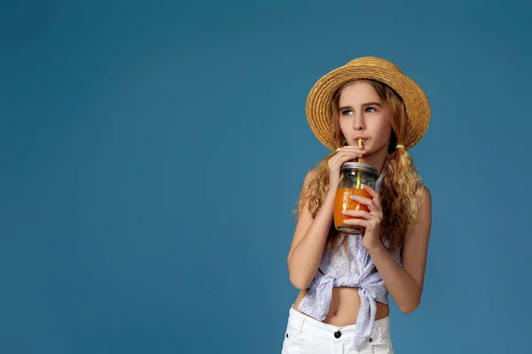 Портрет милой маленькой девочки, пьющей апельсиновый сок — стоковое фото
