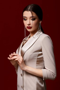 Güzel, güzel, esmer kadın. Kırmızı arka planda uzun saçlı..