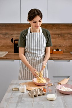 Genç ve güzel ev hanımı mutfakta yemek pişiriyor..