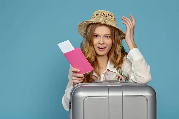 Lächelnde blonde Frau mit grauem Koffer, Pass — Stockfoto