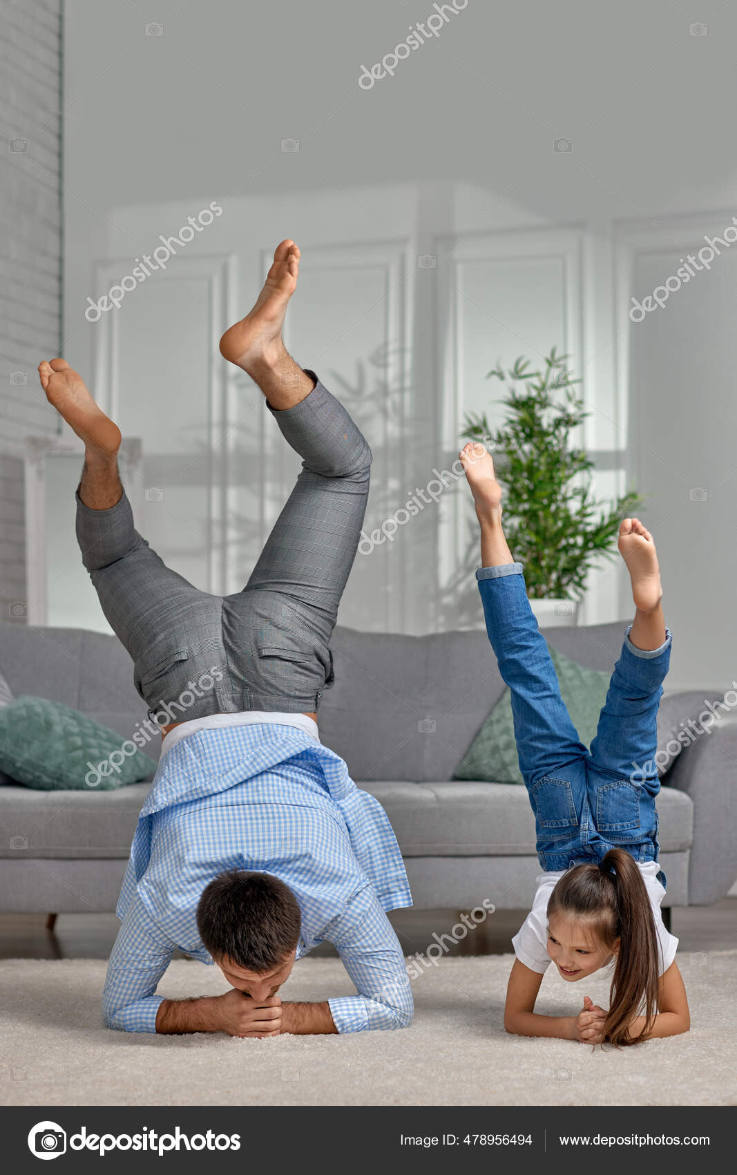 Father copy imitate active child girl doing gymnastic handstand