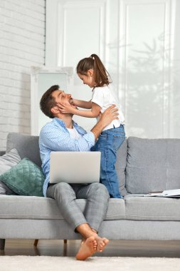 Küçük kız ve yakışıklı babası çalışırken.