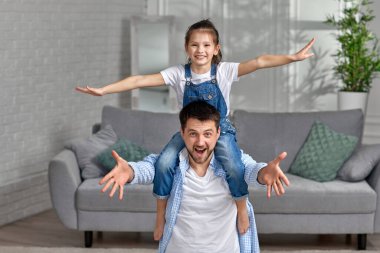 Mutlu baba, tatlı kızını omuzlarına alıyor.