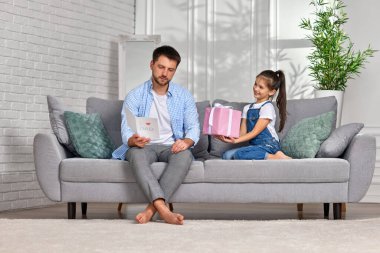 Kızı babasını tebrik ediyor ve ona hediye paketi veriyor..