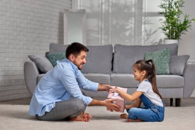 Kızı babasını tebrik ediyor ve ona hediye paketi veriyor..