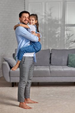 Gülümseyen baba küçük tatlı kızına sarılıyor..