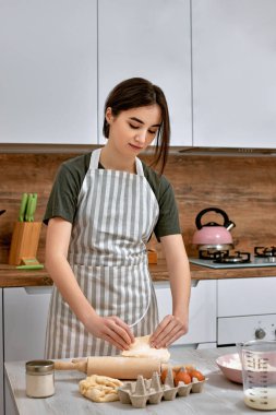 Genç ve güzel ev hanımı mutfakta yemek pişiriyor..