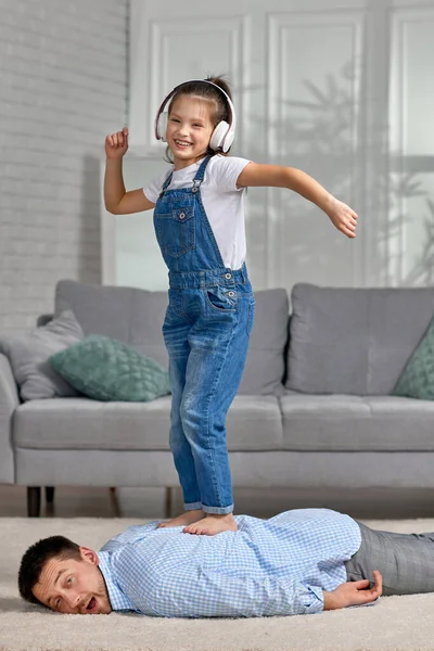 Счастливый маленький ребенок дочь делает массаж отцу — стоковое фото