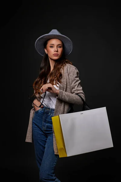 Mujer de moda en gafas de sol sosteniendo bolsas de compras — Foto de Stock