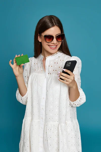 Woman holding credit bank card and mobile phone — Stock Photo, Image