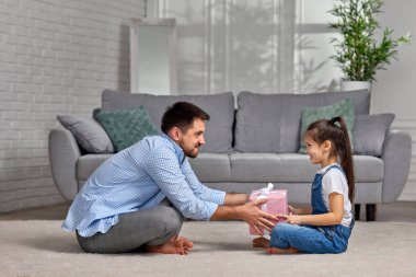 Kızı babasını tebrik ediyor ve ona hediye paketi veriyor..