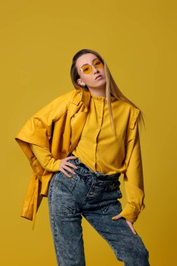 Güneş gözlüklü ve deri ceketli şık sarışın kadın.