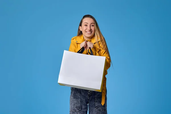 Donna in giacca di pelle contenente shopping bag con acquisti — Foto Stock