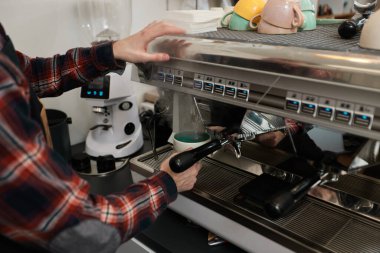 Barista kahve yapmak için kahve makinesi kullanıyor.