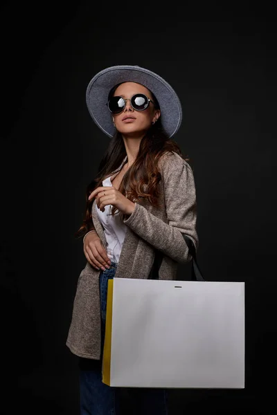 Mujer de moda en gafas de sol sosteniendo bolsas de compras — Foto de Stock