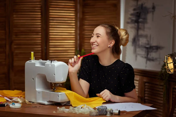 Hermosa costurera joven que trabaja en la máquina de coser —  Fotos de Stock