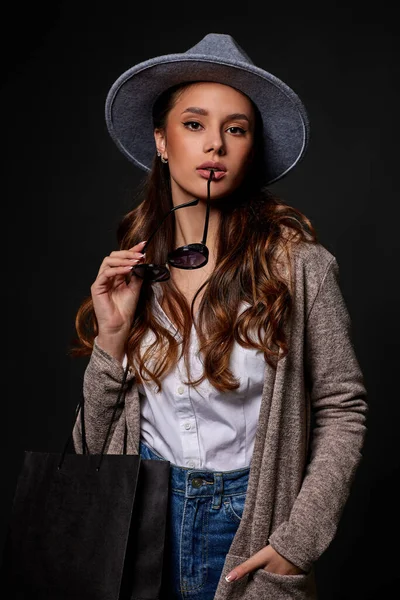 Mulher na moda em óculos de sol segurando sacos de compras — Fotografia de Stock