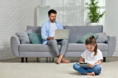 Kafkas babası evde çalışırken çocuk tablet kullanır