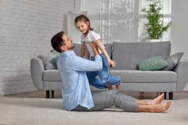 Baba heyecanlı küçük kız çocuğuyla oynuyor.