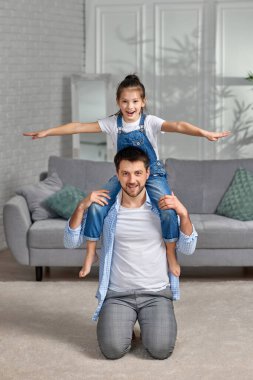 Mutlu baba, tatlı kızını omuzlarına alıyor.
