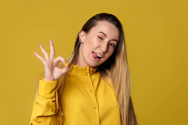 Nő bemutató Ok gesztus sárga háttér. — Stock Fotó