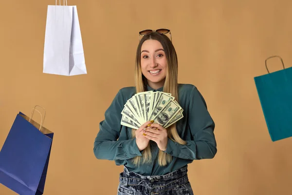 Donna detiene denaro contante sotto dollari pioggia. — Foto Stock