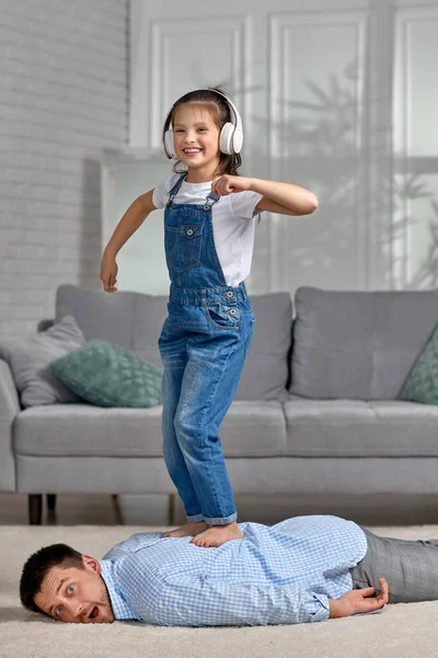 Happy little child daughter doing massage to father — Stock Photo, Image