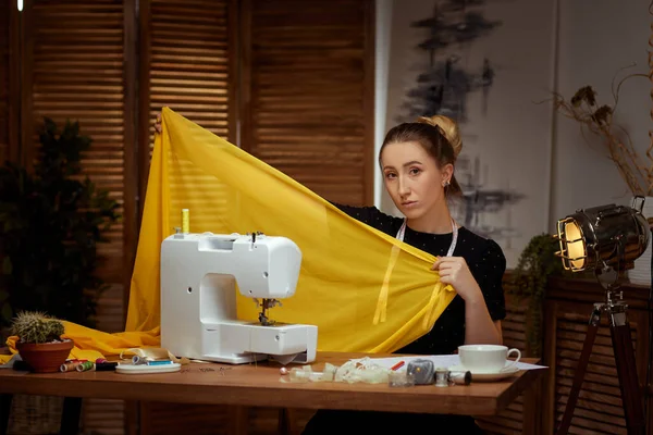 Beautiful young seamstress working on sewing machine — Stock Photo, Image