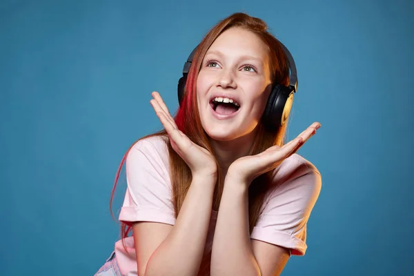 Linda chica adolescente con el pelo rojo en auriculares inalámbricos —  Fotos de Stock