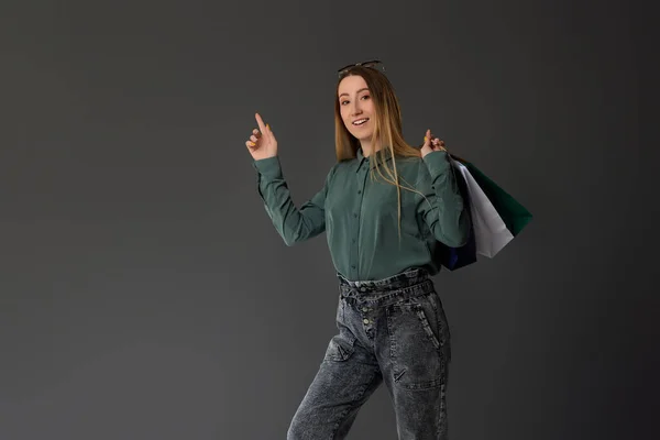 Mulher feliz segurando sacos de compras com compras — Fotografia de Stock