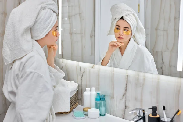 Gyönyörű nő szem foltok fehér fürdőköpenyben a fürdőszobában — Stock Fotó