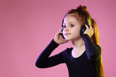 Güneş gözlüklü ve kulaklıklı çocuk müzik dinliyor.