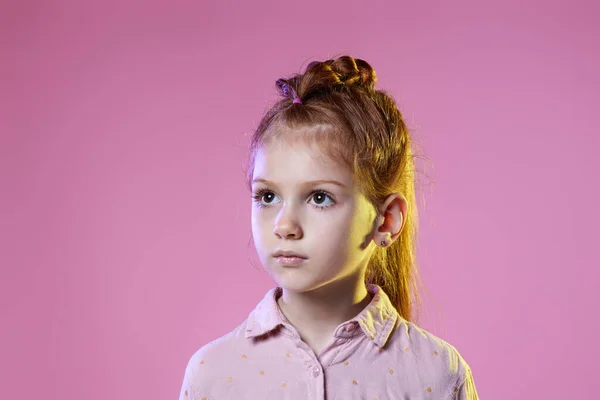Schattig roodharig klein kind meisje op roze achtergrond. — Stockfoto