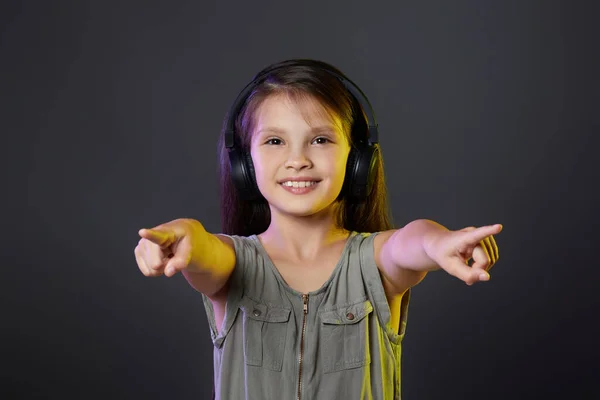 Schattig kind meisje in draadloze hoofdtelefoon luisteren naar muziek — Stockfoto
