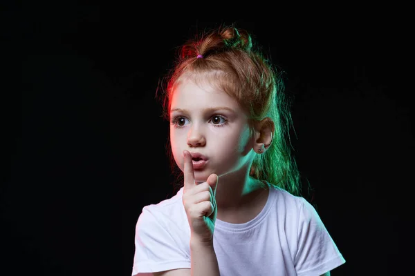 Meisje het maken van een rustige gebaar op zwarte achtergrond — Stockfoto