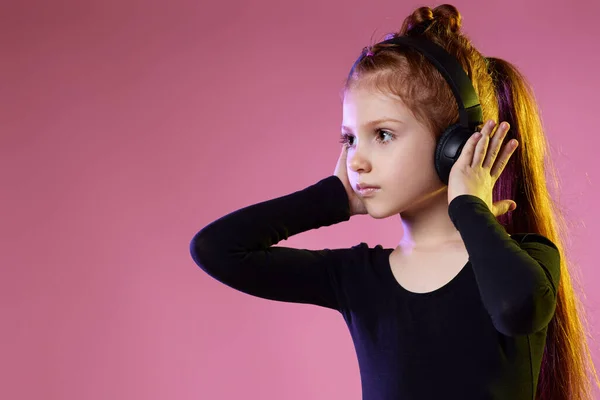 Niña en gafas de sol y auriculares escuchando música — Foto de Stock