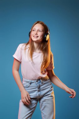 Mavi arka planda yan yana duran üç çocuk kız.