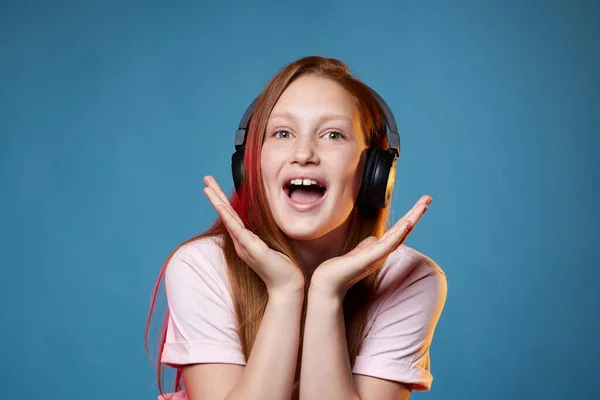 Linda chica adolescente con el pelo rojo en auriculares inalámbricos —  Fotos de Stock