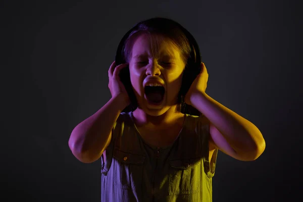 Schattig kind meisje in draadloze hoofdtelefoon luisteren naar muziek — Stockfoto