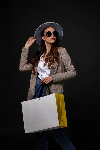 Μοντέρνα γυναίκα σε γυαλιά ηλίου κρατώντας τσάντες για ψώνια — Φωτογραφία Αρχείου
