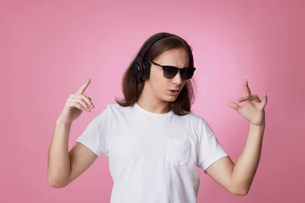 Homem de óculos de sol ouve música com fones de ouvido e danças — Fotografia de Stock